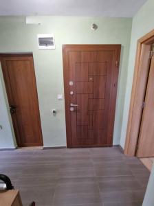 Duas portas de madeira num quarto com piso em azulejo em Апартамент Плевен em Pleven