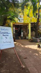 una señal sentada en el suelo frente a un edificio en The goanvibes hostel and cafe, en Anjuna