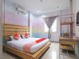 ein Schlafzimmer mit einem großen Bett mit roten Kissen in der Unterkunft OYO 90021 Tokidoki X Ah123 Residence in Medan
