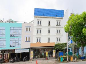 ein weißes Gebäude mit blauem Dach auf einer Straße in der Unterkunft OYO 90021 Tokidoki X Ah123 Residence in Medan