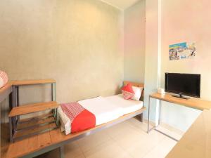 Kleines Zimmer mit einem Bett und einem Flachbild-TV. in der Unterkunft OYO 90021 Tokidoki X Ah123 Residence in Medan