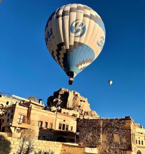 a hot air balloon flying over a building at Karlık Cave Suite Cappadocia in Uçhisar