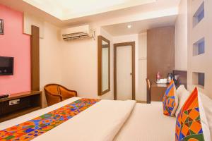 1 dormitorio con 1 cama y TV en una habitación en FabHotel Emerald, en Ranchi