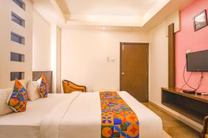 Habitación de hotel con cama y TV en FabHotel Emerald, en Ranchi