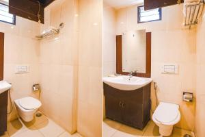 a bathroom with a sink and a toilet and a mirror at FabHotel Emerald in Rānchī