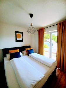 1 Schlafzimmer mit 2 Betten und einem großen Fenster in der Unterkunft Ferienwohnung Lucia in Schiefling am See