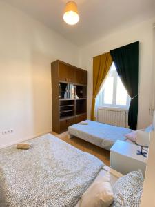 1 dormitorio con 2 camas y ventana grande en Kerepesi City Apartment en Budapest