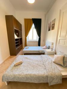 1 dormitorio con 2 camas y TV. en Kerepesi City Apartment en Budapest
