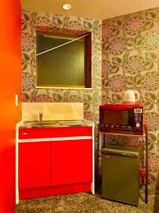 a kitchen with a red sink and a microwave at Villa Inuyama - Vacation STAY 87603v in Inuyama