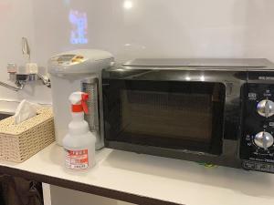 a microwave sitting on a counter next to a mixer at HOTEL StoRK Naha Shintoshin - Vacation STAY 27620v in Naha