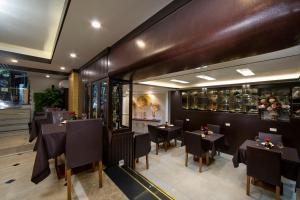 um restaurante com mesas e cadeiras num quarto em Splendid Holiday Hotel Spa em Hanói