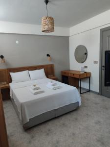 een slaapkamer met een groot bed en een televisie bij Thalassa Hotel Bozcaada in Bozcaada