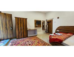 a bedroom with a bed and a rug in it at Eve Resort, Pachmarhi in Pachmarhī