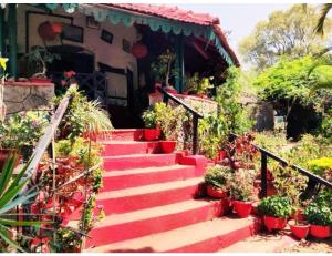 eine Treppe mit Topfpflanzen vor einem Haus in der Unterkunft Eve Resort, Pachmarhi in Pachmarhi