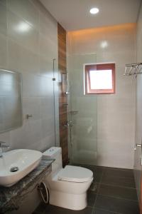 a bathroom with a toilet and a sink and a shower at Sông Mê Home in Vĩnh Long
