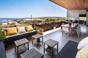 eine Terrasse mit einem Sofa, einem Tisch und Stühlen in der Unterkunft Oceana - sweeping ocean views, short walk to beach in Gracetown