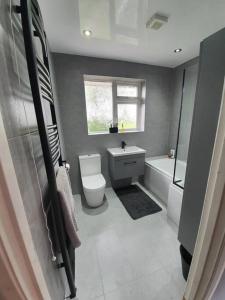 y baño con aseo, bañera y lavamanos. en Luxury 3 bed coastal house en North Tyneside