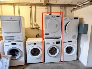 two washing machines and a washer and dryer in a room at Howald 2 BR Apartment with Private Garage & Garden in Bonnevoie