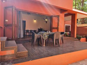 een eetkamer met een tafel en stoelen op een patio bij Nivritti Villa in Matheran
