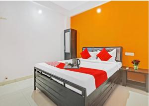 a bedroom with a large bed with an orange wall at KHUSH EXECUTIVE in Pune