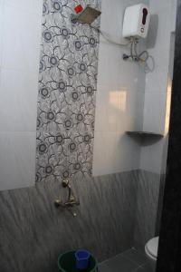a bathroom with a shower with a sink and a toilet at KHUSH EXECUTIVE in Pune