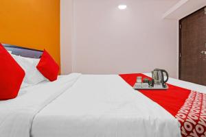 プネにあるKHUSH EXECUTIVEのベッドルーム(白いベッド、赤い枕付)