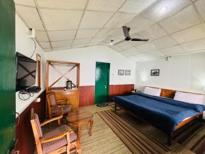 1 dormitorio con 1 cama, mesa y sillas en Room on the Roof, Viraatkhai-Chakrata, By Himalayan Eco Lodges en Chakrāta