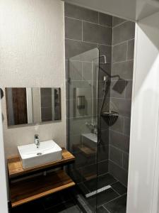 La salle de bains est pourvue d'un lavabo et d'une douche. dans l'établissement BURSA, à Taraz