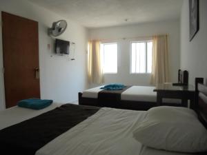 Cette chambre comprend 2 lits et une fenêtre. dans l'établissement Hotel Joohn Gay only LGBTIQ, à Melgar