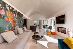 uma sala de estar com um sofá e um mural de peixe em Trullo Brenda. Originale e spettacolare em San Michele Salentino