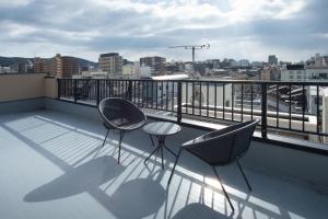 two chairs and a table on a balcony with a view at Design Hotel Kyoto Fuyacho in Kyoto