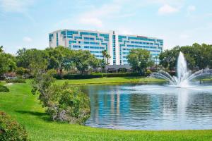 uma fonte num lago em frente a um edifício em Renaissance Orlando Airport Hotel em Orlando