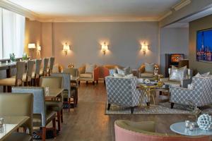 a restaurant with couches and tables and chairs at Renaissance Orlando Airport Hotel in Orlando