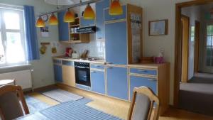 a kitchen with blue cabinets and a table with chairs at Ferienwohnung Stralsund in Stralsund