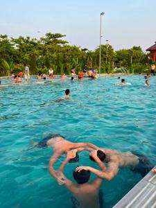 grupa ludzi pływających w basenie w obiekcie Đại Dương - Ocean Hotel w mieście Diễn Châu