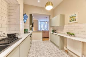 una cucina con armadi bianchi e piano di lavoro di Modern Luxury 2-bedroom Oasis In Heart Of Whitley a Whitley Bay
