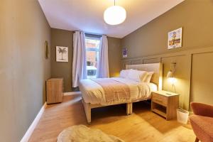 una camera con letto e finestra di Modern Luxury 2-bedroom Oasis In Heart Of Whitley a Whitley Bay