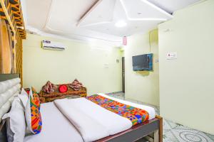 1 dormitorio con 2 camas y TV en FabHotel Golden Horizon en Ranchi