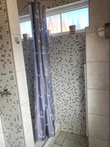 a shower curtain in a bathroom with a window at Ferienhaus Steilküste in Fehmarn +25 photos