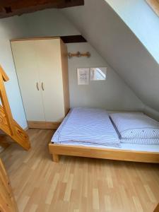 a small bedroom with a bed and a cabinet at Ferienhaus Leuchtturm in Fehmarn