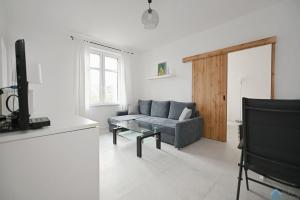 a living room with a couch and a tv at Bianco by 3City Rentals in Sopot