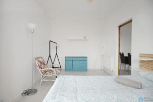 a bedroom with a bed and a chair and a dresser at Bianco by 3City Rentals in Sopot