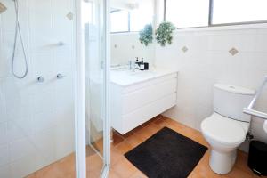 a bathroom with a shower and a toilet and a sink at Bayview Oasis- With pool in Hardys Bay