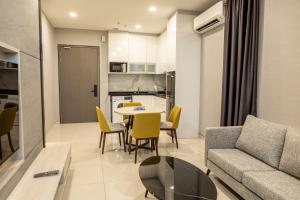een woonkamer met een bank en een tafel en stoelen bij Societe Suites By iHost Global in Kuala Lumpur