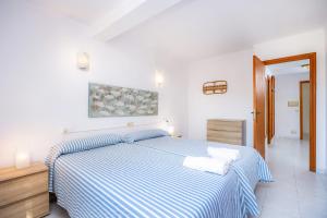 1 dormitorio con 1 cama azul y blanca y 2 toallas en Apartamento mhm 4, en Cala Ratjada