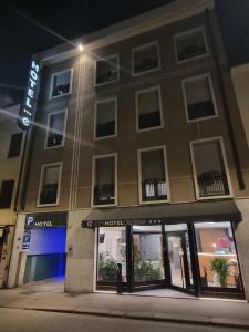 un bâtiment avec une façade de magasin la nuit dans l'établissement CityHotel Cristina Vicenza, à Vicence