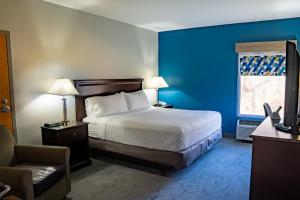 una camera d'albergo con letto e sedia di Holiday Inn Express Carneys Point New Jersey Turnpike Exit 1, an IHG Hotel a Carneys Point