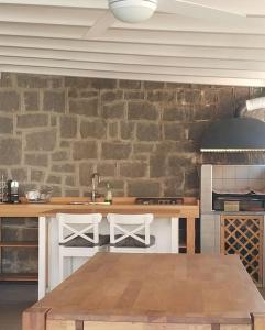 uma cozinha com uma mesa e uma parede de pedra em Appartamento Super Confortevole em Gaglianico
