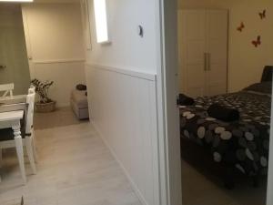 um quarto branco com uma cama, uma mesa e uma secretária em Appartamento Super Confortevole em Gaglianico