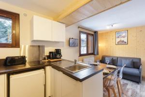 a small kitchen with a sink and a table at Hameau Des Grands Montets - Apartment 127 - Happy Rentals in Chamonix
